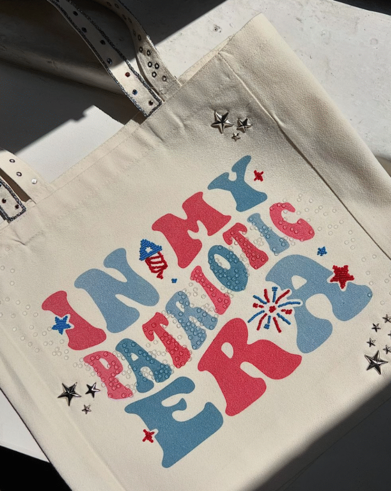 Tote bag with "In My Patriotic Era" design in red, white, and blue with rhinestones and star embellishments.