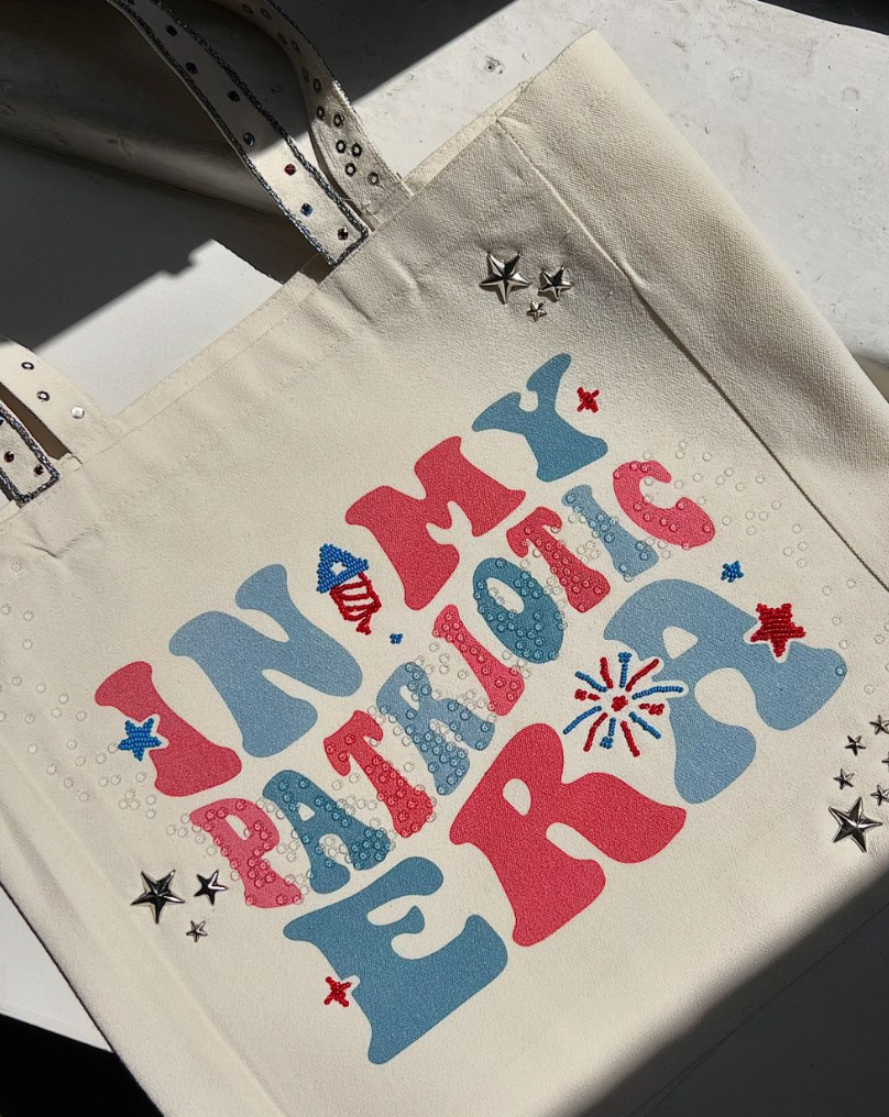 Tote bag with "In My Patriotic Era" design in red, white, and blue with rhinestones and star embellishments.