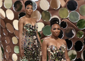 Venus Williams wearing a strapless mirrored sequin dress with a sculptural silhouette, standing against a backdrop that mimics the texture of her gown.