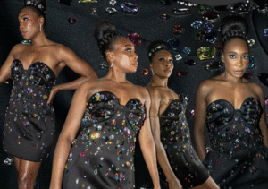 Venus Williams stands confidently in a black gown with structural ruffle details, against a moody backdrop featuring embroidery hoops and red fabric.