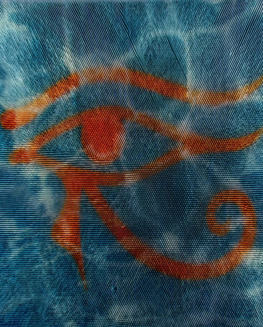 Fabric with a red Eye of Horus symbol painted over a rippling blue background resembling water.