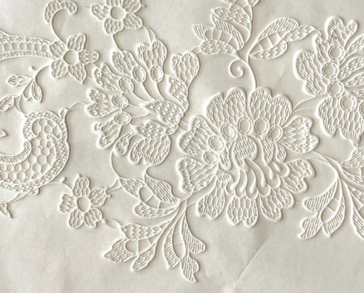 White floral embroidery on fabric.