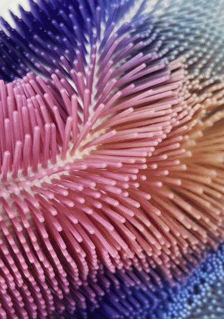 Close-up of colorful, spiked 3D textile resembling coral.