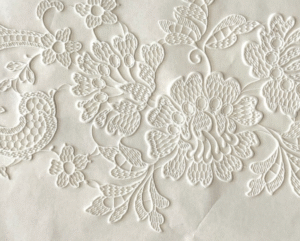 White floral embroidery on fabric.