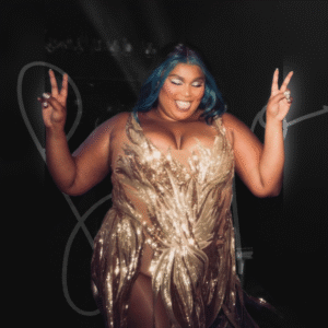 Lizzo smiling and holding up two peace signs in a golden fringe dress.