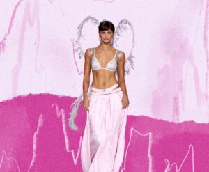 Model in soft pink skirt and silver top with subtle angel wings.
