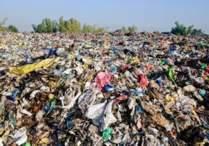 Massive landfill filled with discarded clothing and textile waste.
