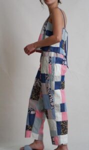 Side profile of a woman wearing a colorful patchwork jumpsuit.