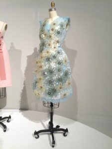 Blue floral embellished dress displayed on a mannequin against a white backdrop.