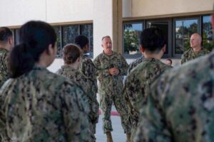 Navy officer addresses colleagues during an outdoor formation.