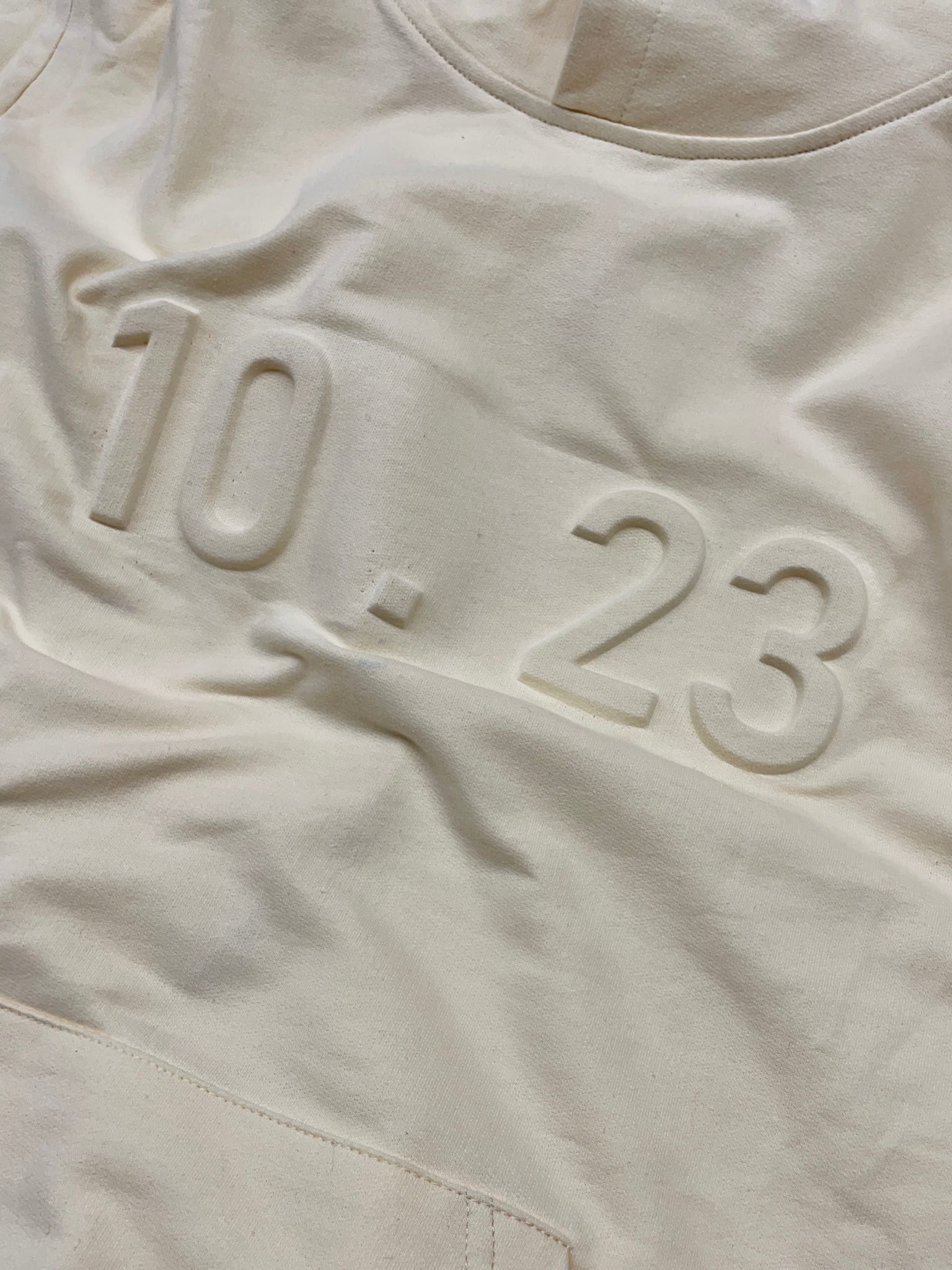 White fabric embossed with the numbers “10.23”.