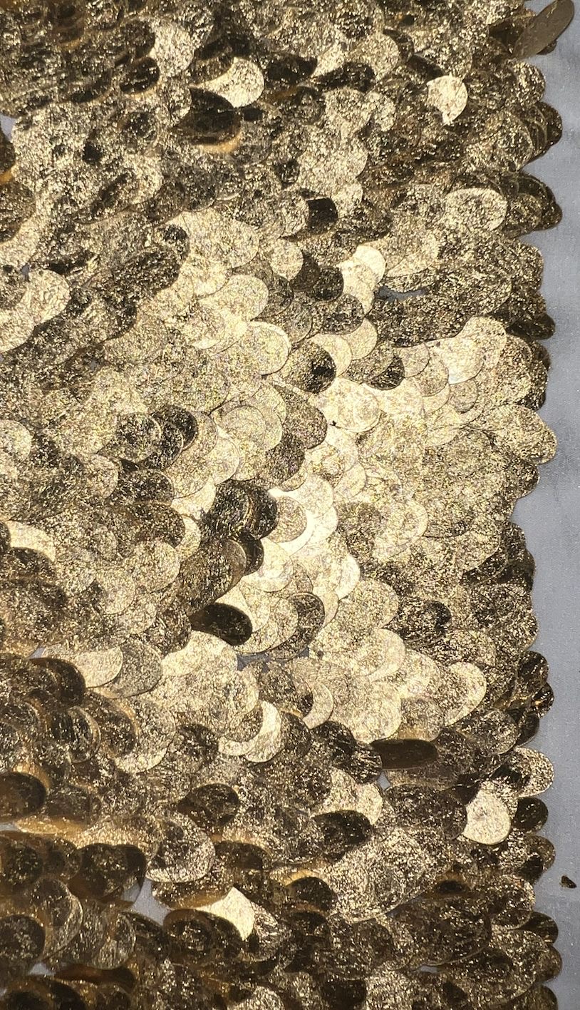Close-up of overlapping gold sequins creating a dense texture.