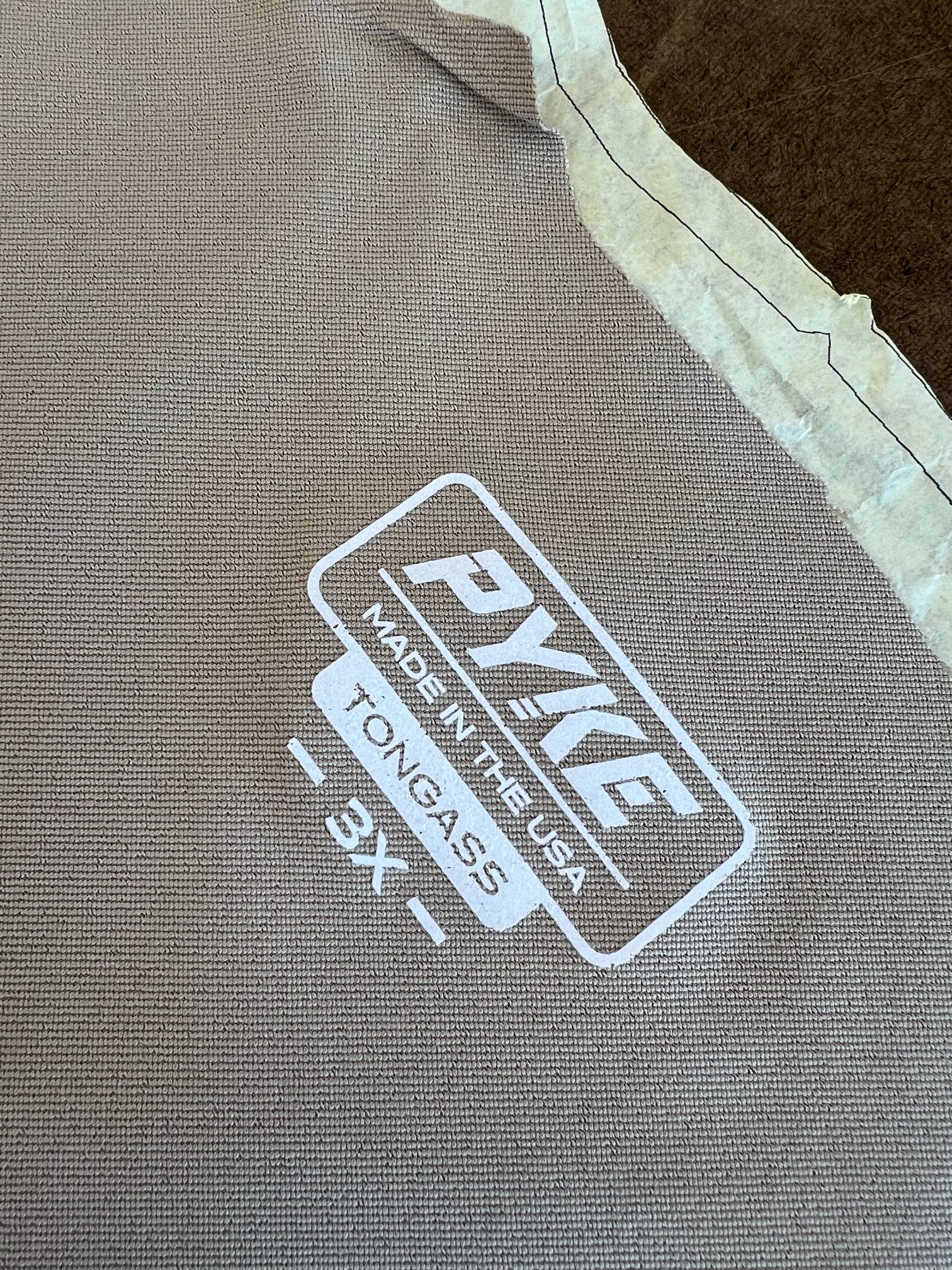 Close-up of PYKE "Made in the USA" label on brown textured fabric