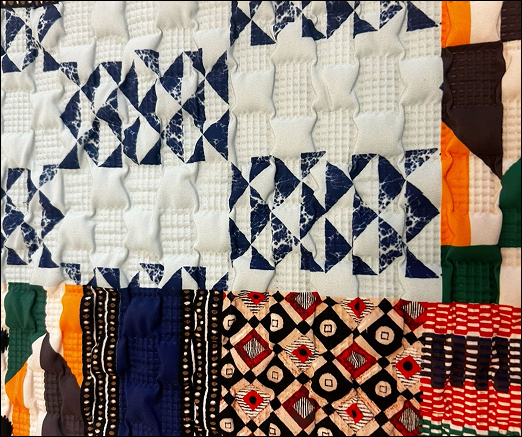 Mixed-media quilted textile with blue geometric and multicolor ethnic-inspired patterns