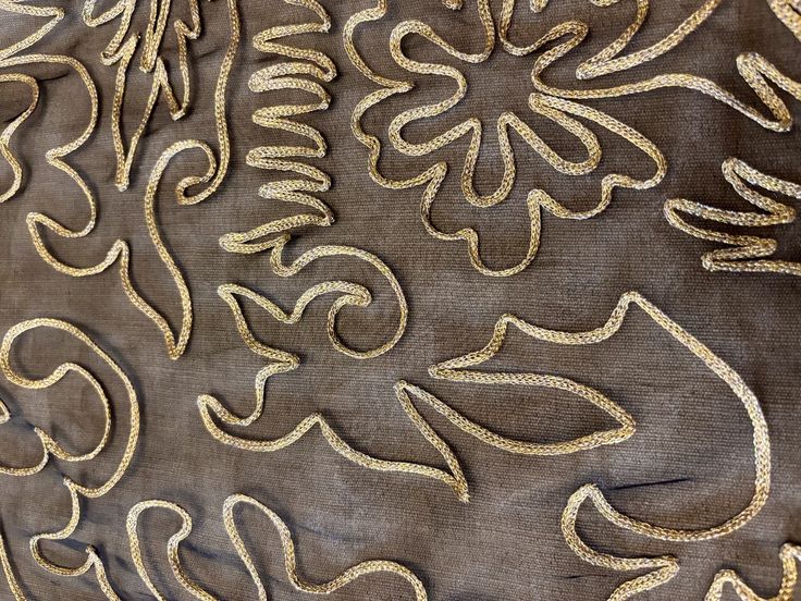 Embroidered floral outline on dark organza.