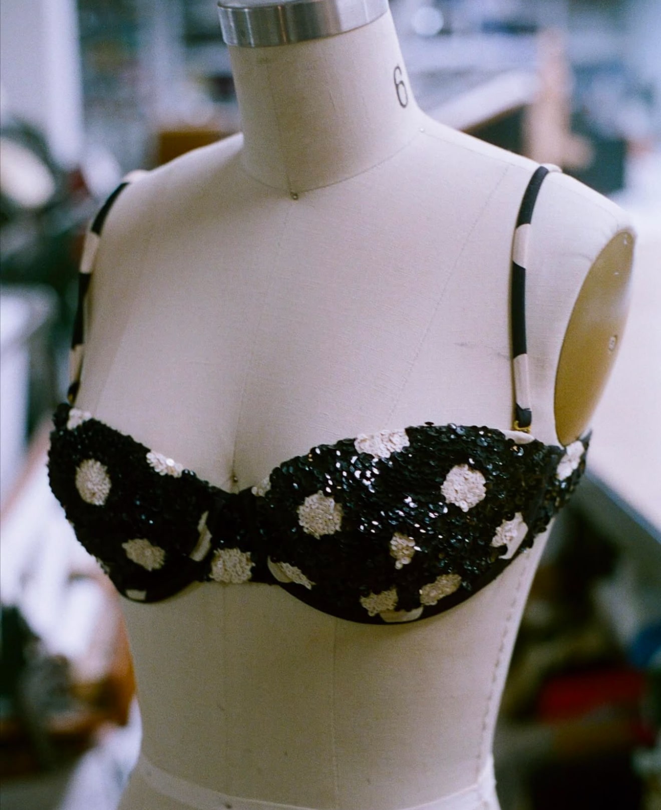 Embroidered black and white floral bra displayed on mannequin torso.