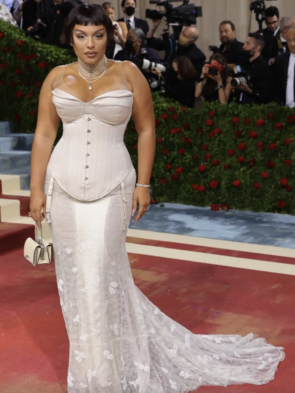 Paloma Elsesser wearing a strapless ivory corset gown with lace train and structured silhouette on the Met Gala red carpet.