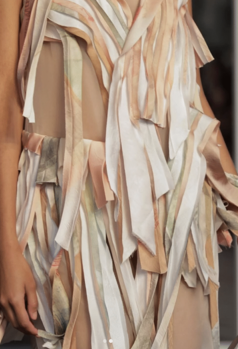 Runway shot of a model wearing Jason Wu SS26 patchwork collage dress, featuring bias-cut strips of silk and novelty fabrics in custom colorways, with raw-edge satin and sheer organza details.