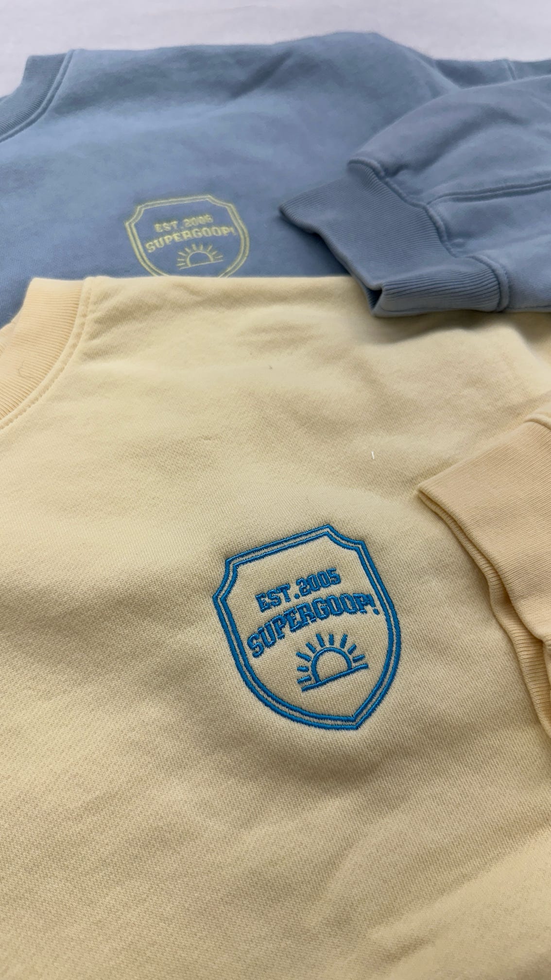 Close-up of a Supergoop! sweater embroidered with custom designs, part of a college tour giveaway.