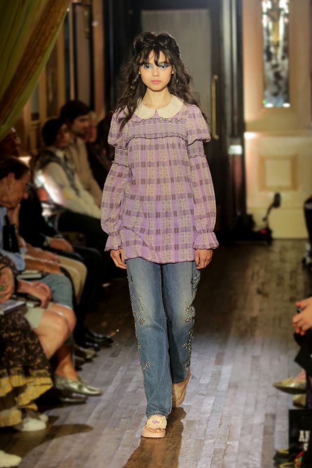 Runway shot of a model wearing an Anna Sui SS26 look featuring delicate shirring and hand-applied embellishments, creating a romantic, textured silhouette.