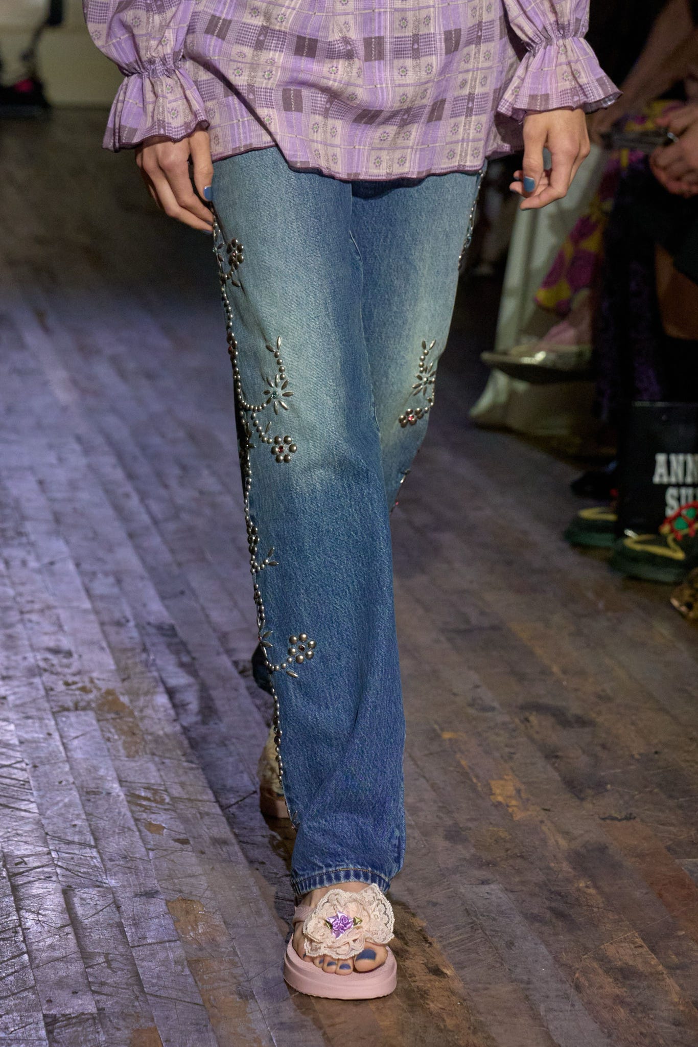 Runway shot of a model wearing an Anna Sui SS26 look featuring delicate shirring and hand-applied embellishments, creating a romantic, textured silhouette.