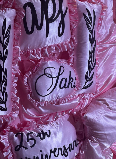 Custom chain-stitched pillow cases arranged on a backdrop for the APF Gala photo-op.
