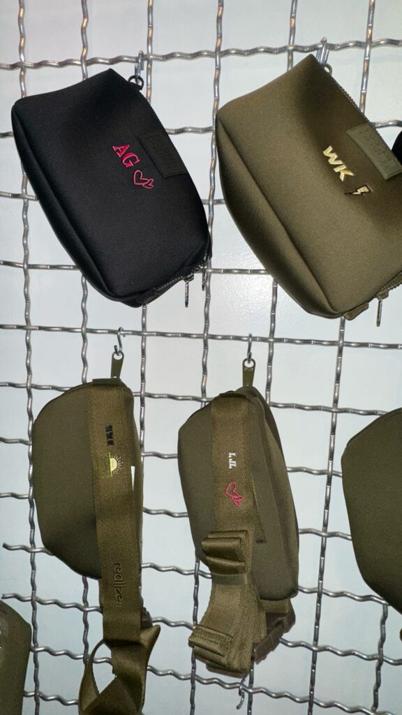 Guests having their Dagne Dover pouches custom embroidered live at the Taboola event.
