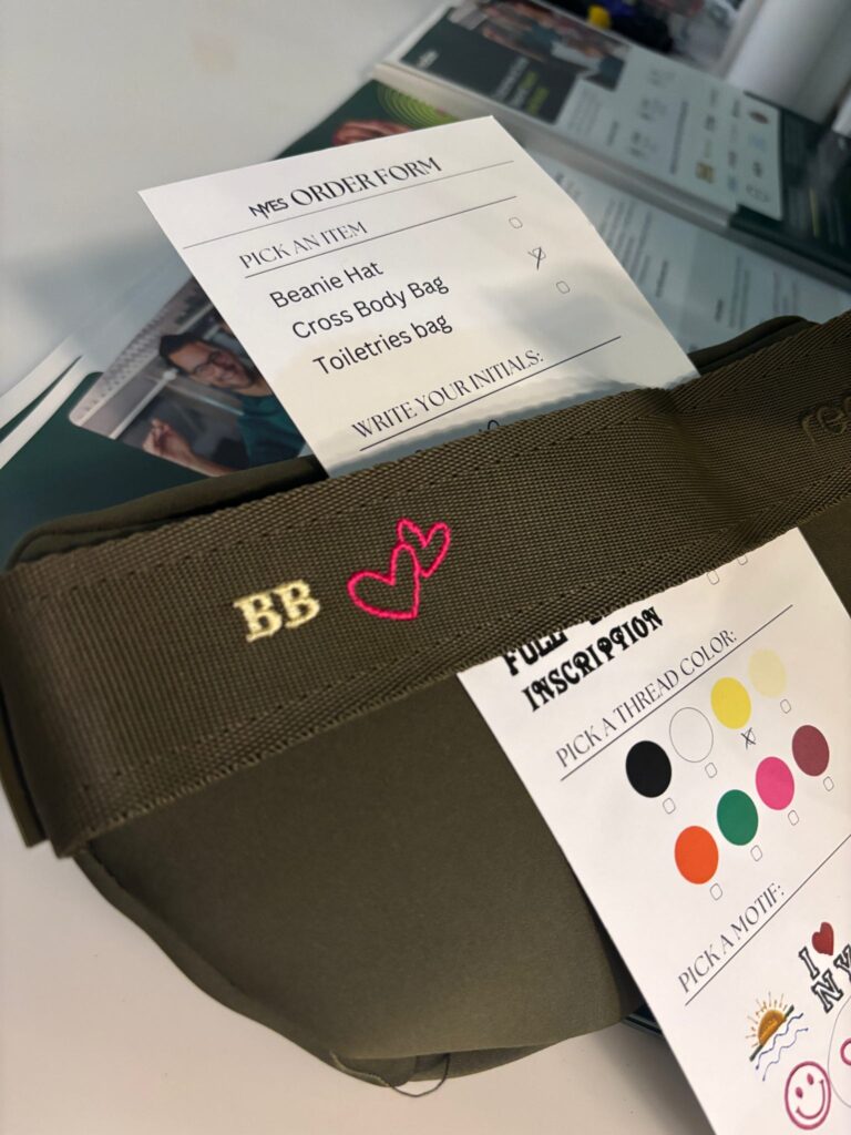 Guests having their Dagne Dover pouches custom embroidered live at the Taboola event.