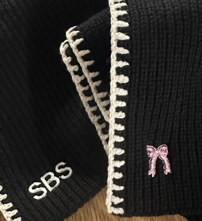Custom embroidered scarves and hats displayed at the TJ Maxx x Marshalls holiday event.