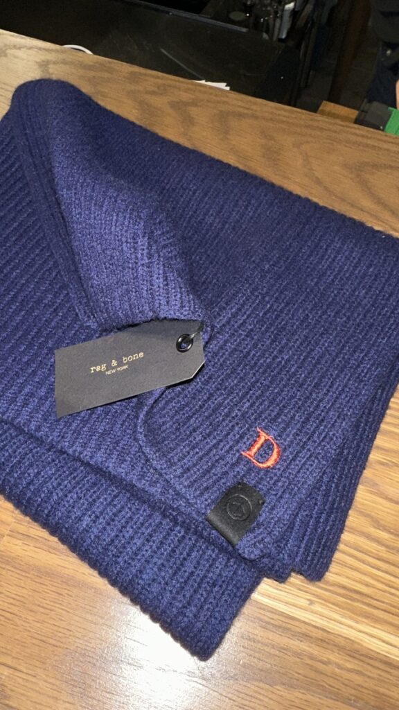 Custom embroidered scarves and hats displayed at the TJ Maxx x Marshalls holiday event.