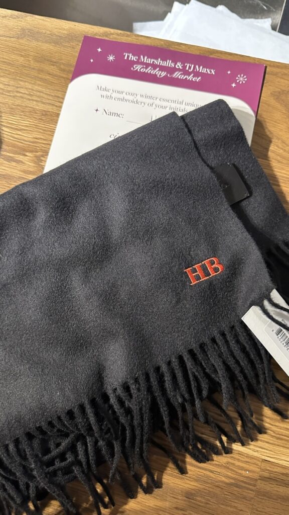 Custom embroidered scarves and hats displayed at the TJ Maxx x Marshalls holiday event.