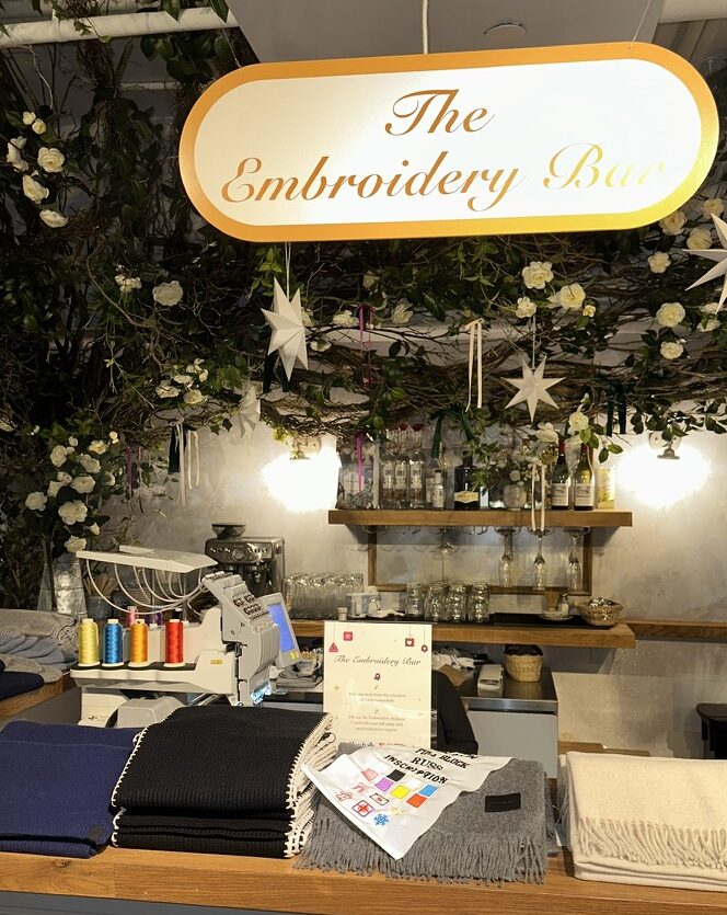 Custom embroidered scarves and hats displayed at the TJ Maxx x Marshalls holiday event.
