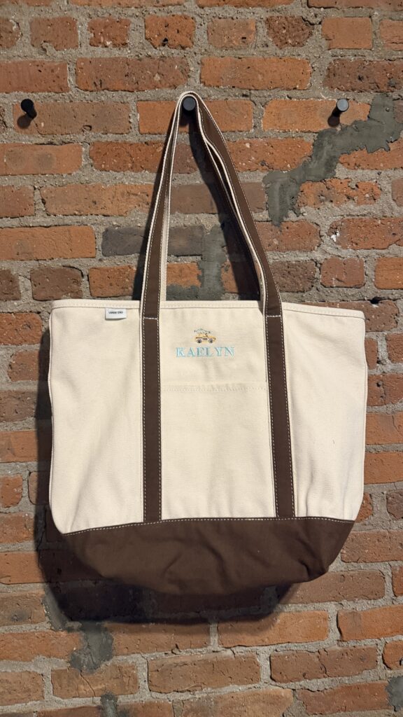 Embroidery samples showing NYES’s custom font options, thread color selections, and stitched holiday motifs, including a penguin, bow, Christmas tree, taxi, bear, and star—displayed in hoops for Lands’ End’s Chaotically Customized Holiday Shop