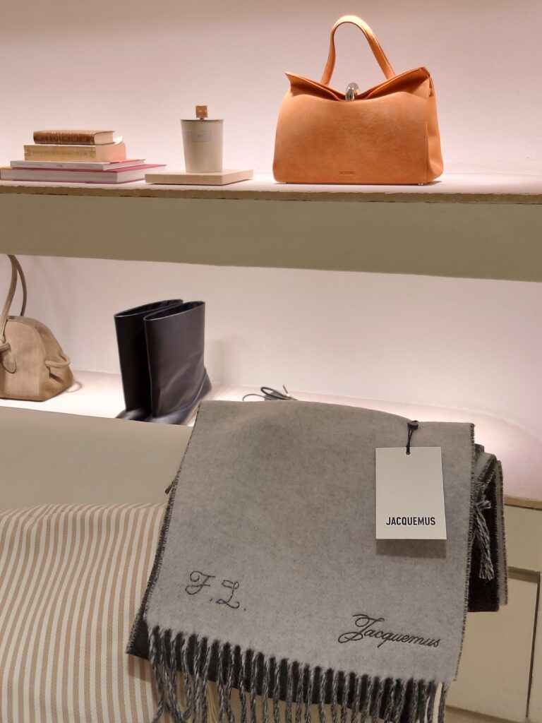 Hand-embroidered black initials stitched onto a beige cashmere scarf with hand-tied fringe detailing