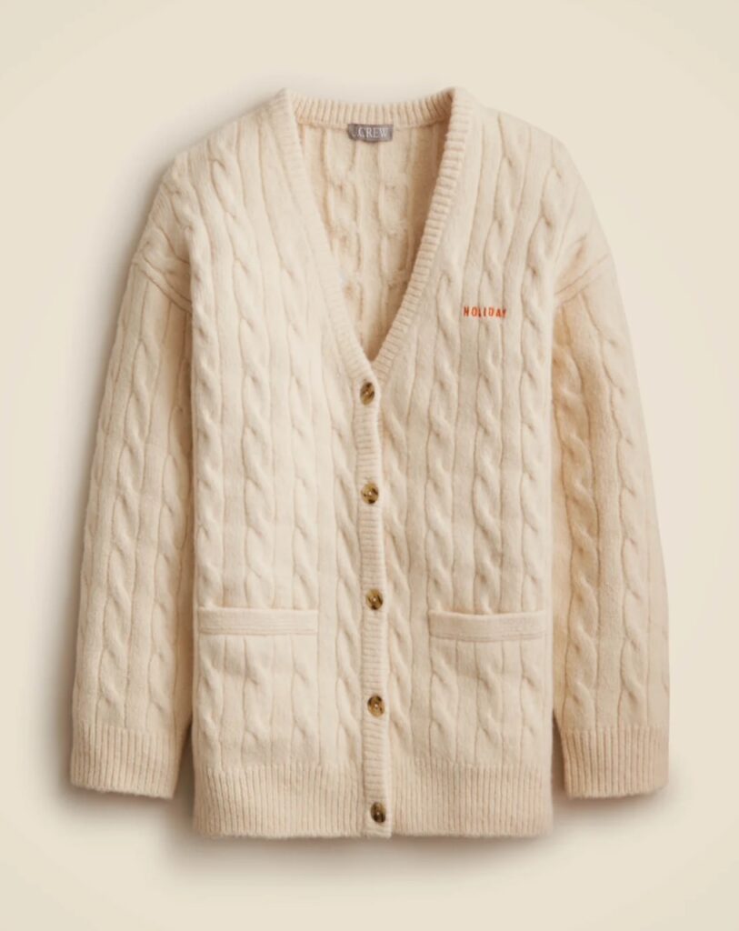 Cream cable knit cardigan with subtle Holiday logo embroidery on the chest