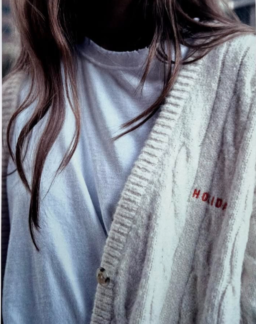 Cream cable knit cardigan with subtle Holiday logo embroidery on the chest