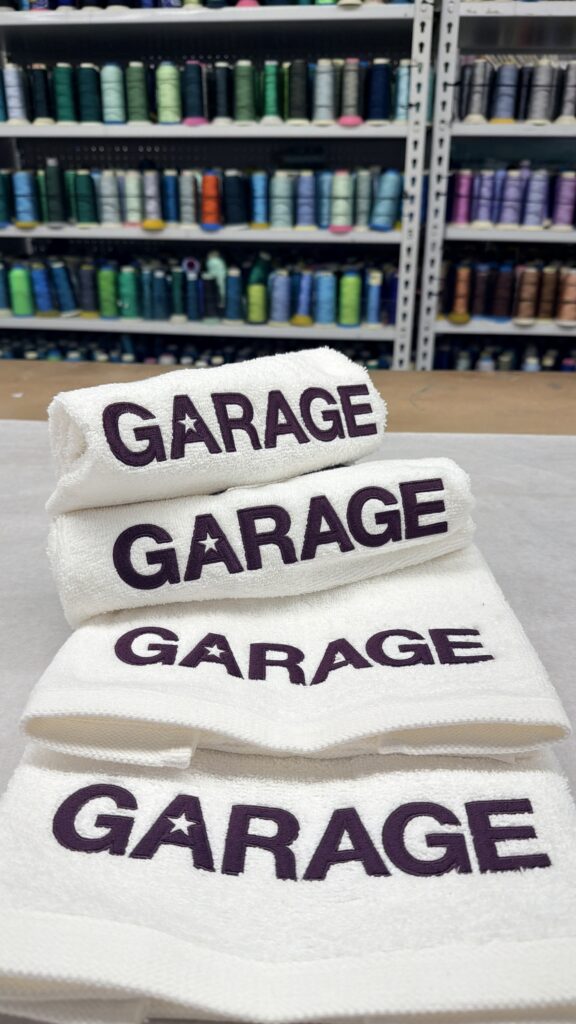Multiple white towels layered with Garage logo embroidery