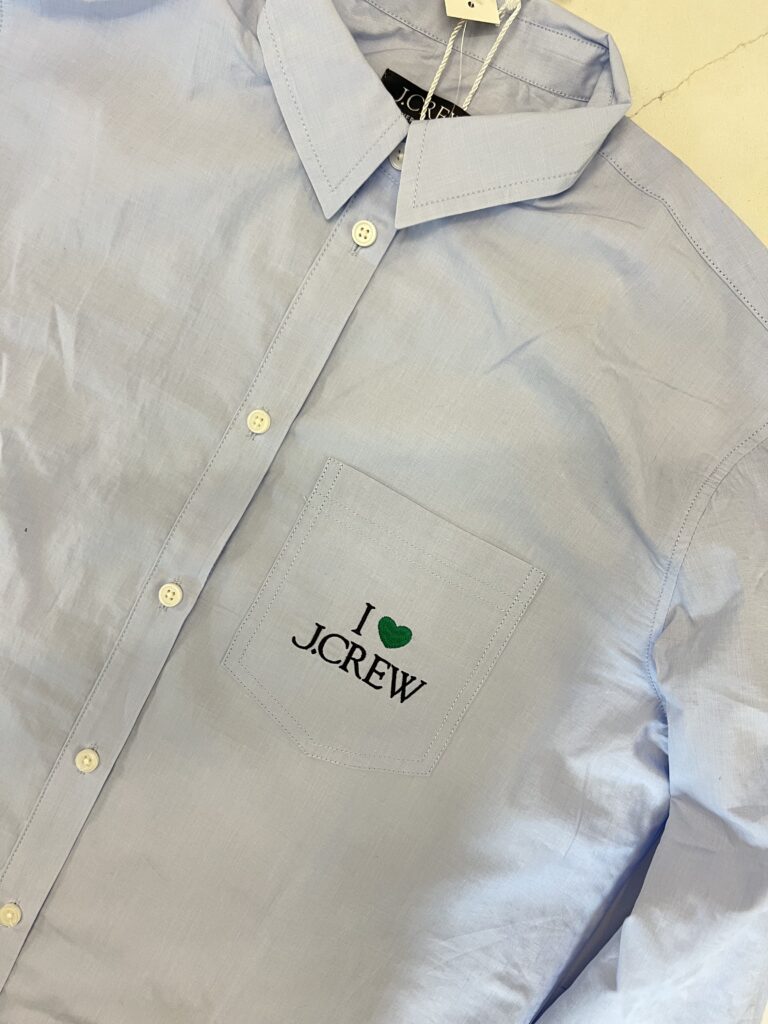 Close-up of embroidered I Love J.Crew logo above chest pocket on lightweight woven shirt
