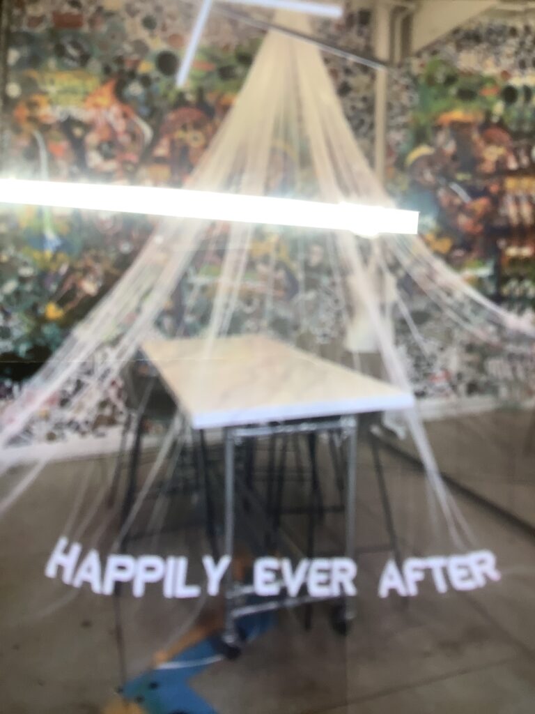 Custom embroidered bridal veil with “Happily Ever After” text laid out in studio workspace