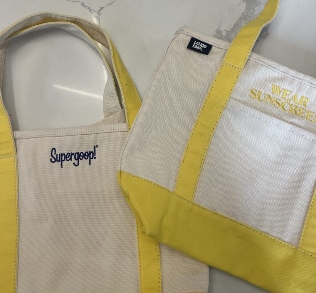 Canvas tote bag featuring custom embroidered Supergoop! logo with yellow accents
