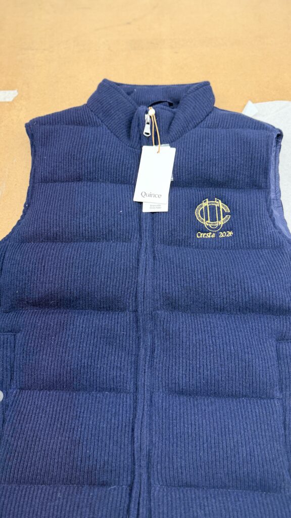 Detailed view of gold digital embroidery stitched onto textured wool fabric