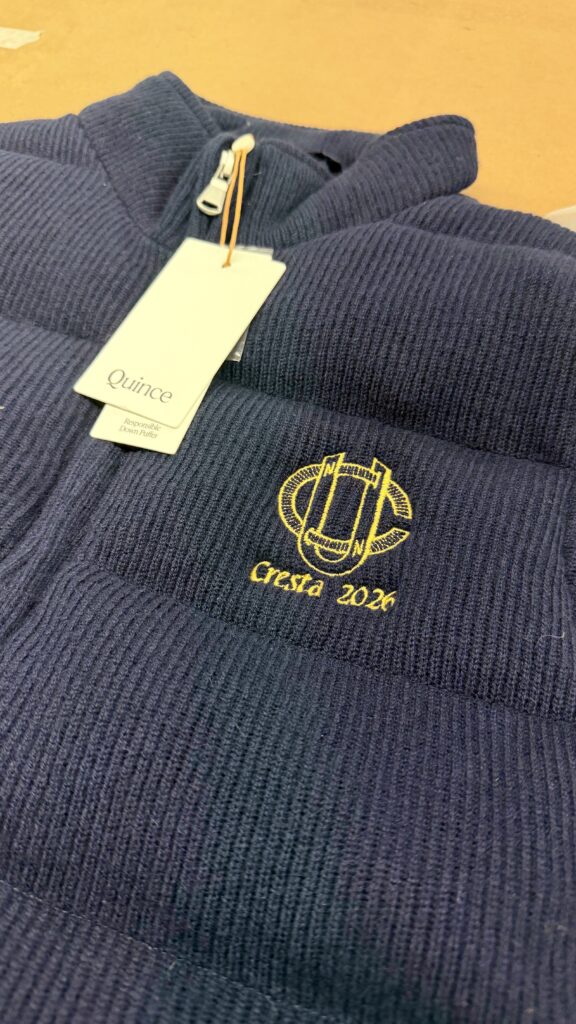 Detailed view of gold digital embroidery stitched onto textured wool fabric