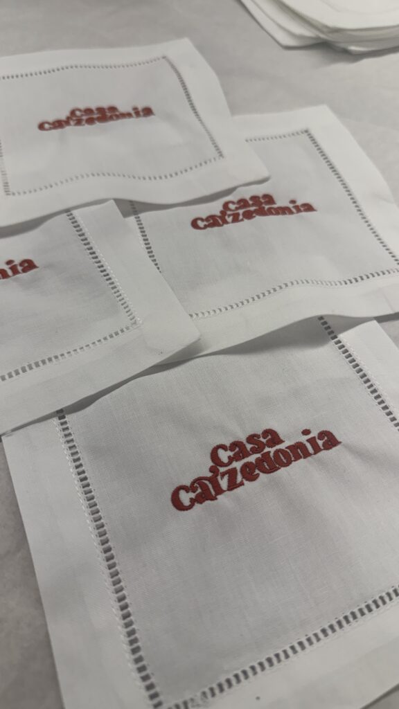 Close-up of detailed embroidery on branded linen napkins for luxury beachside event