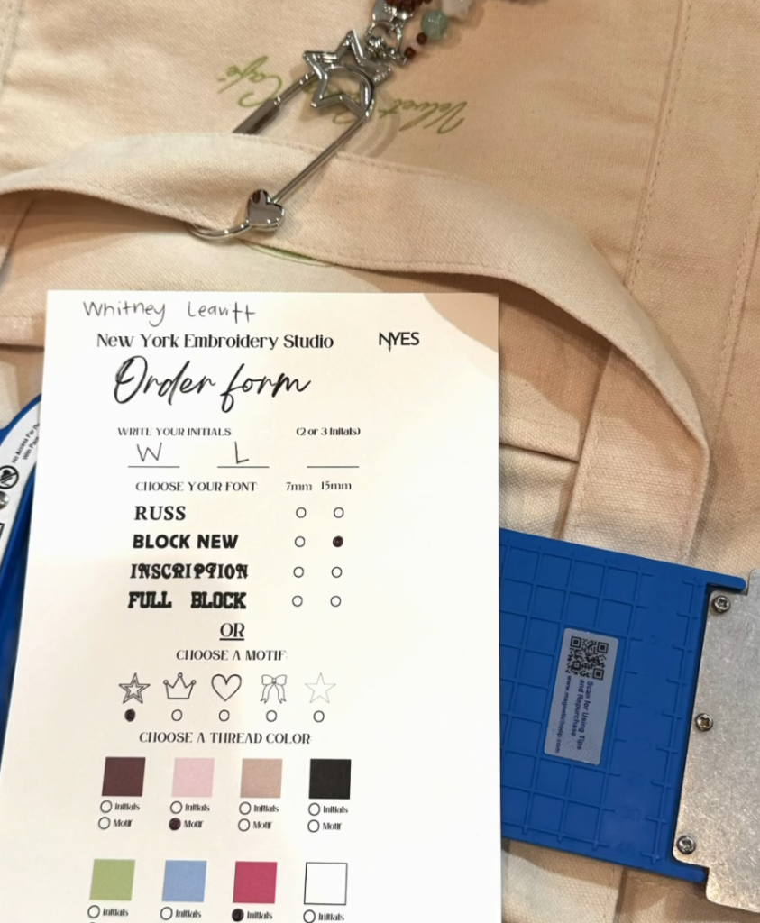 Guest customizing a tote bag at NYES live embroidery event at Velvet Caviar Cafe