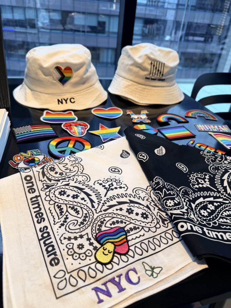 Live embroidery and heat press customization station creating personalized Pride bucket hats and bandanas during the One Times Square Pride celebration.