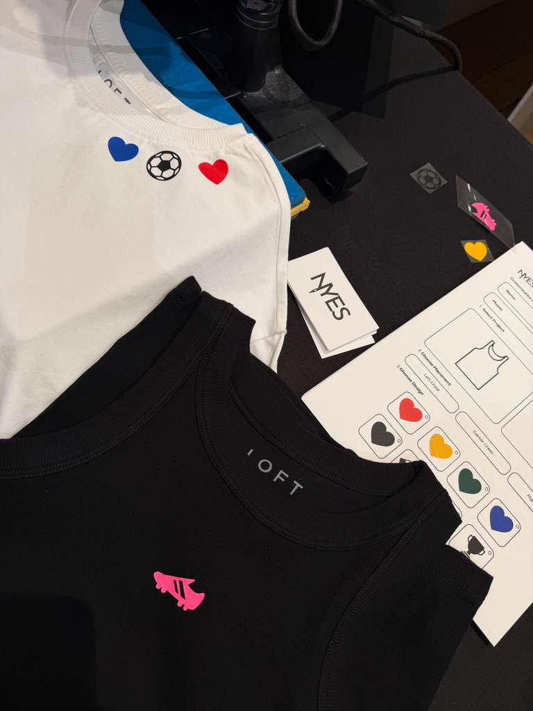 LOFT guests customizing T-shirts and tank tops with heat-pressed graphics during a World Cup-themed retail event.