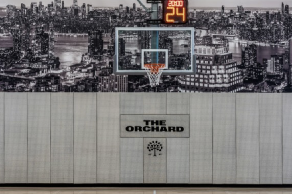 Close-up detail of The Orchard logo embroidered onto Concertex fabric for custom athletic facility wall padding