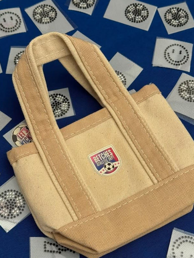 Guest participating in a live tote bag customization experience at a Betches World Cup event