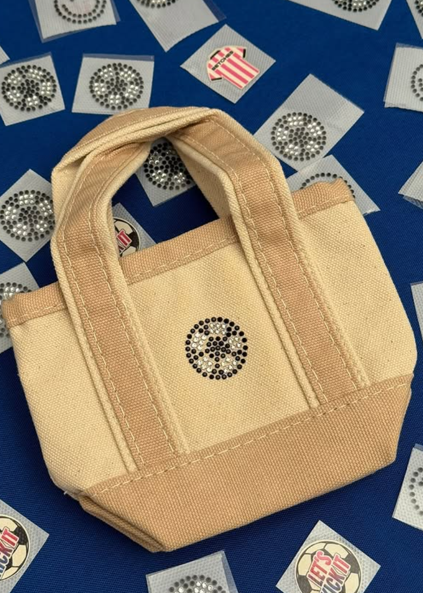 NYES embroidering a guest name onto a tote bag at a World Cup event