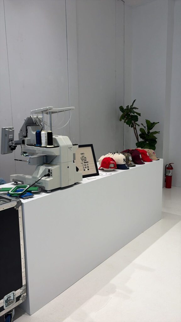 Hat being personalized with live embroidery at a DSW event
